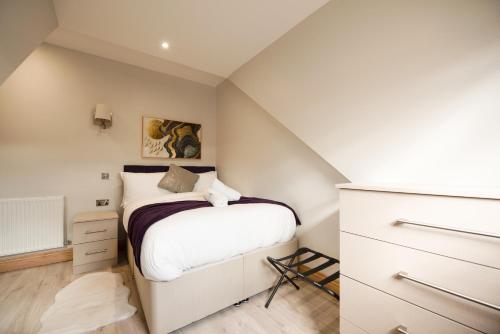 a small bedroom with a bed and a dresser at Elm House in Reading