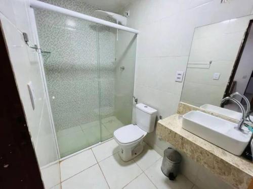 a bathroom with a shower and a toilet and a sink at Linda casa com piscina in São Miguel do Gostoso