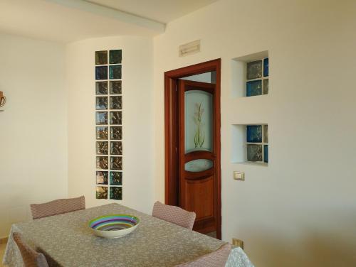 uma sala de jantar com uma mesa e uma porta de madeira em Villa Madreselva em Cinisi