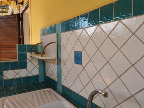 uma casa de banho com banheira e azulejos verdes e brancos em Villa Madreselva em Cinisi