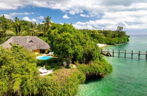 eine Insel im Wasser mit einem Haus und einem Pool in der Unterkunft Zanzi Resort in Zanzibar City