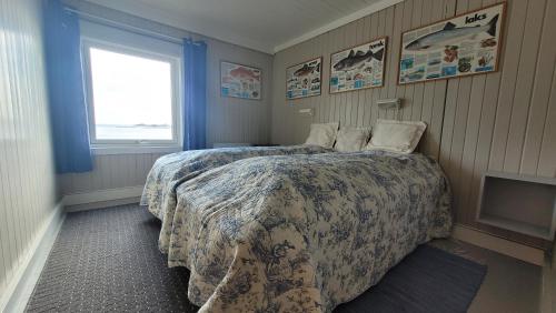 a hotel room with a bed and a television at Solodden, Authentic rorbu in Lofoten in Sennesvik