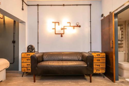 a leather couch sitting in a room with a wall at Pass the Keys London Industrial studio flat Harry Potter Theme in London