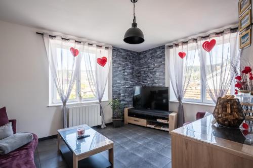 a living room with hearts hanging from the windows at Gite au coin de la petite chapelle gitesdes2vallees in Cornimont