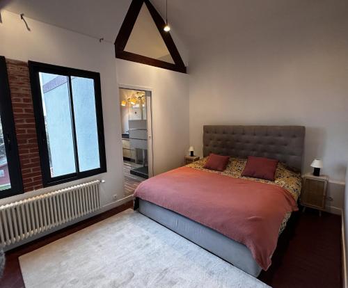 ein Schlafzimmer mit einem Bett und einem großen Fenster in der Unterkunft Villa avec jardin in Saint-Cloud