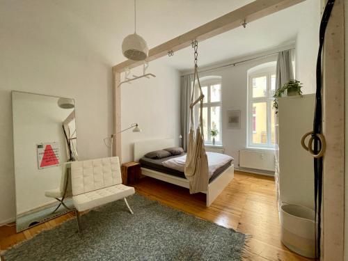 een slaapkamer met een bed en een witte stoel bij charming and cozy apartment in Berlijn