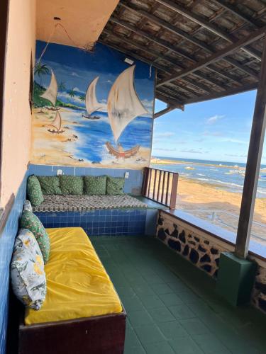 a room with a bed and a view of the ocean at Pousada Tubarão in Camaçari