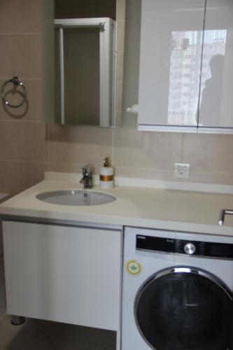 a kitchen with a sink and a washing machine at Ailenizle keyifle kalabileceğiniz eşsiz bir daire in Istanbul