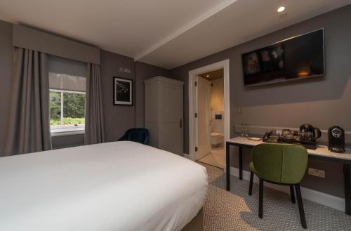 a hotel room with a bed and a desk with a computer at The Scott in Edinburgh