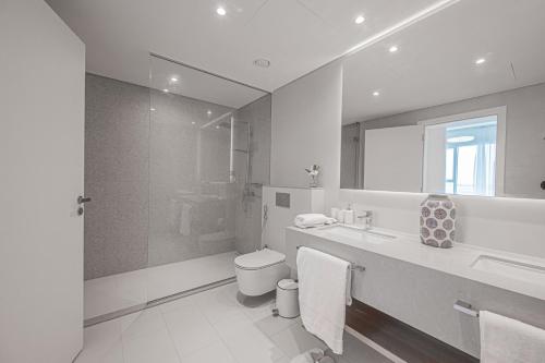 a bathroom with a toilet and a sink and a shower at La Vie in Dubai