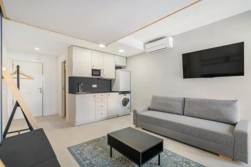 a living room with a couch and a tv at MADRIVER apartamentos reformados con parking gratuito in Madrid