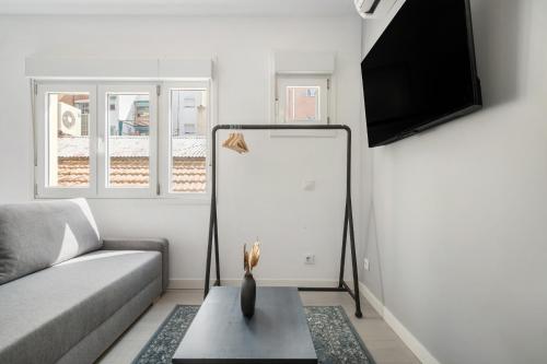a living room with a couch and a flat screen tv at MADRIVER apartamentos reformados con parking gratuito in Madrid