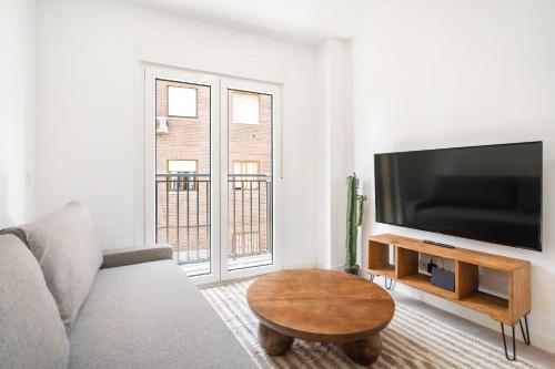 een woonkamer met een bank en een flatscreen-tv bij apartamentos en vallecas in Madrid