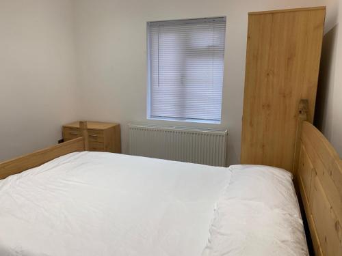 a bedroom with a white bed and a window at Private room, renovated with large size white desk In SE9 6PG in London