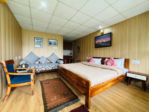 1 dormitorio con 1 cama grande y 1 sofá en Himalayan High, Auli, By Himalayan Eco Lodges, en Jyotirmath