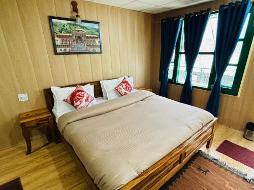 a bedroom with a bed with red pillows and a window at Himalayan High, Auli, By Himalayan Eco Lodges in Joshīmath