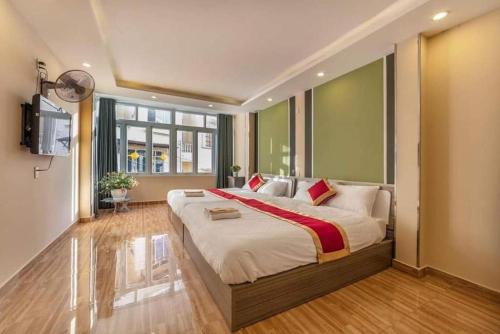a bedroom with a large bed and a television at ROSE HOSTEL DALAT in Da Lat