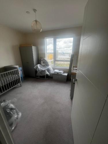 an empty room with a crib and a window at 2bed flat with the Balcony in Hoo