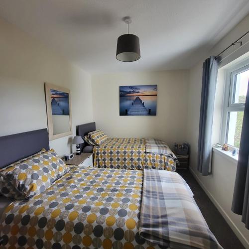 a bedroom with two beds and a window at RAWSON COTTAGE LOVELY 2 BEDROOM SEMI RURAL in Stranraer