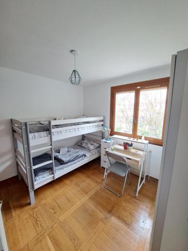Cette chambre blanche dispose d'une table, d'une table et d'une fenêtre. dans l'établissement L'écureuil parisien Maison de charme avec jardin proche Paris, à Cormeilles-en-Parisis