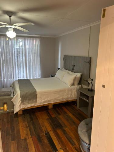 a bedroom with a bed and a ceiling fan at Oudam Overnight Accomodation in Bloemfontein
