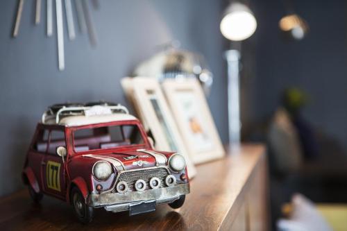 a toy car sitting on top of a wooden table at Tolani Nimman Villa Chiang Mai in Chiang Mai