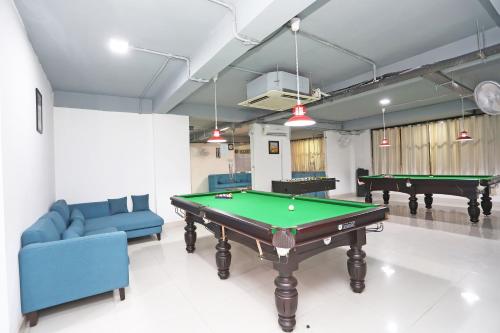 a living room with a pool table and couches at Super Capital O Levanti Near Aravali Biodiversity Park in Gurgaon