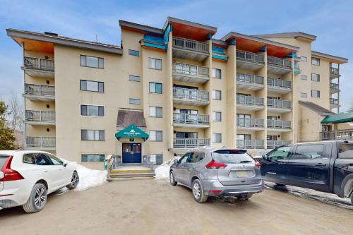 two cars parked in a parking lot in front of a building at Mountain Green in Killington