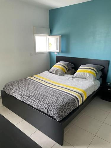 un lit dans une chambre avec un mur bleu dans l'établissement Appartement T2, à Montpellier