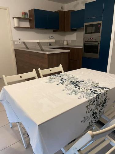 une cuisine avec une table blanche et deux chaises dans l'établissement Appartement T2, à Montpellier