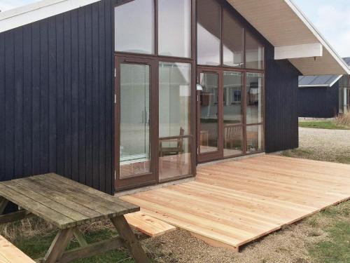 a wooden deck on the side of a house at 7 person holiday home in Ulfborg in Thorsminde