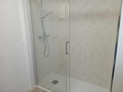 a shower stall with a glass shower door at apartamento Somo in Somo