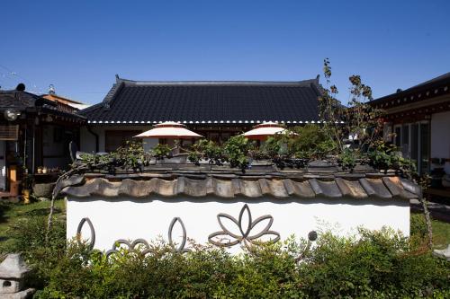 a stone wall with plants on it in front of a building at Hanok Raon in Gyeongju