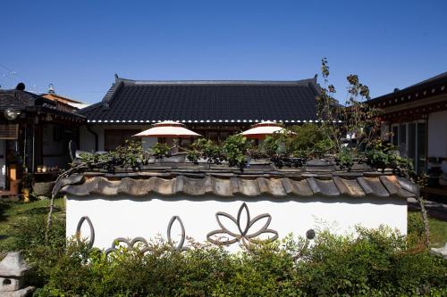 una pared de piedra con plantas delante de un edificio en Hanok Raon, en Gyeongju