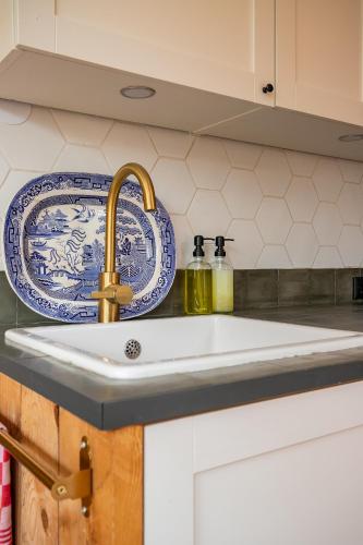 a kitchen sink with a blue and white plate at Het Zeepaartje, knus en gezellig in Noordwijkerhout