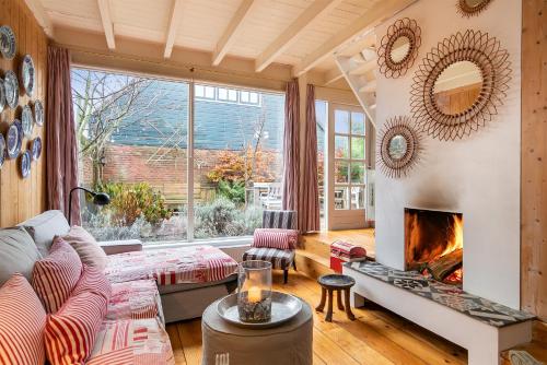 a living room with a couch and a fireplace at Het Zeepaartje, knus en gezellig in Noordwijkerhout