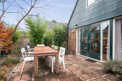 a wooden table and chairs on a patio at Het Zeepaartje, knus en gezellig in Noordwijkerhout