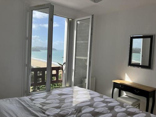 une chambre avec un lit et une vue sur l'océan dans l'établissement Les Pieds dans l'Eau, à Donville-les-Bains