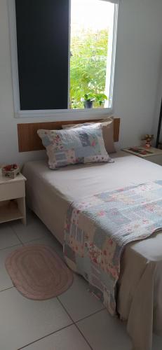 Bett in einem Zimmer mit Fenster in der Unterkunft Suíte completa em condomínio fechado in Petrolina