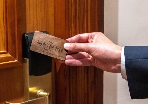 a person in a suit is holding a piece of wood at The Aberdeen Dyce Hotel in Dyce