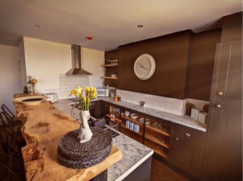 a kitchen with a table with a vase of flowers on it at The Beulah Apartments in Leeds