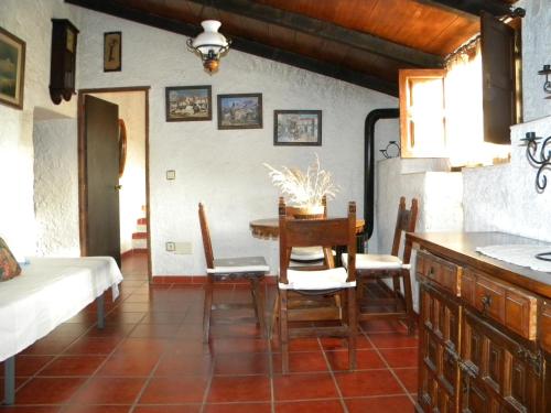 una cucina e una sala da pranzo con tavolo e sedie di Cortijo Pulgarín Bajo ad Alfarnatejo