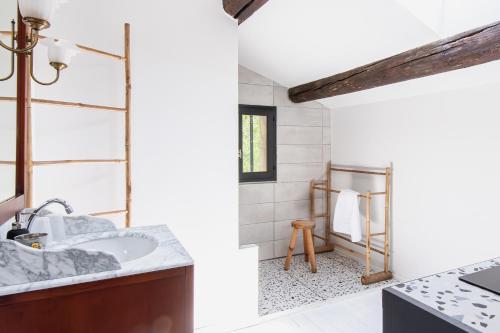 ein Bad mit einem Waschbecken und einem Spiegel in der Unterkunft La Madeleine Arles in Arles