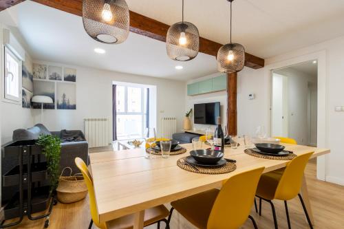 comedor y sala de estar con mesa de madera y sillas en INSIDEHOME Apartments - Val Central, en Valladolid