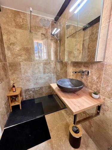 La salle de bains est pourvue d'un lavabo noir sur un comptoir en bois. dans l'établissement La Cigalière, à Saint-Raphaël