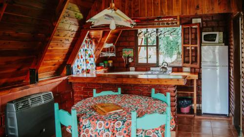 uma cozinha com uma cama e um lavatório numa cabina em Cabañas Nosotros em Lago Puelo