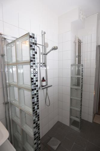 uma casa de banho com um chuveiro e uma porta de vidro em Haha em Gotemburgo