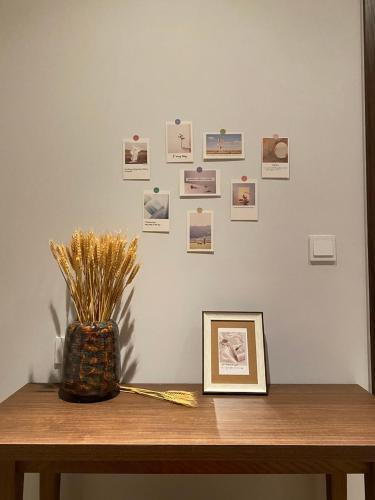 a table with a picture on a wall with photos at Apec Mandala Cham Bay Mui Ne 5* in Ấp Thiẹn Ái