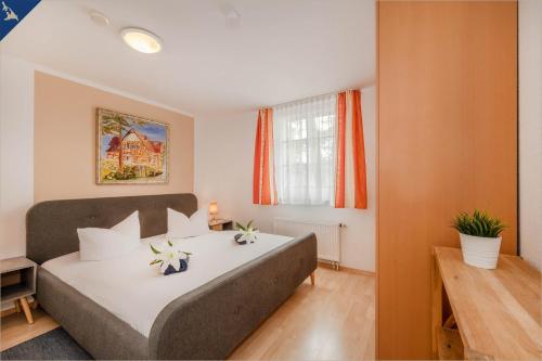 コルスヴァントにあるWaldsiedlung Waldhaus App 2.1のベッドルーム1室(花の咲く大型ベッド1台付)
