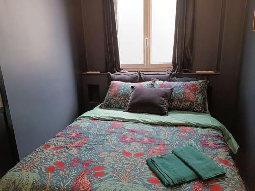 un lit avec deux oreillers dessus dans une chambre dans l'établissement Studio Gare, à Rouen